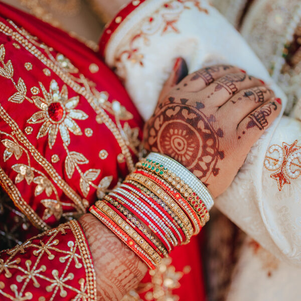 Bride and husband holding hands in an Indian wedding.