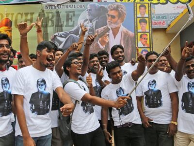 Fans take a group picture in front of the "Kabali" movie poster.