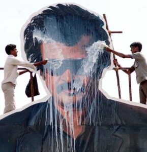 Fans pour milk on a billboard image of Rajinikanth, a famous moviestar in the South India film industry.